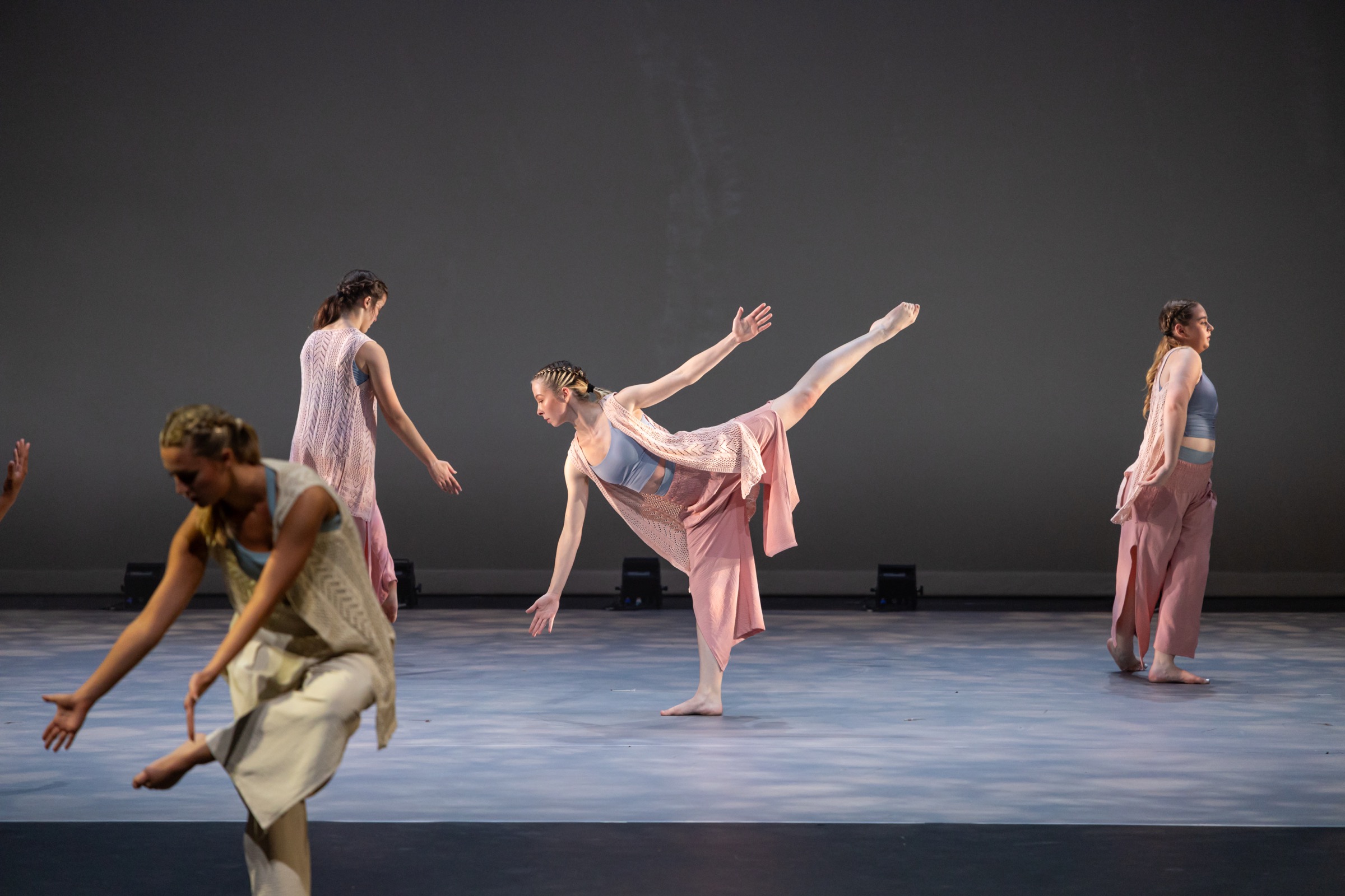 Flying/Falling ensemble performing a balanced stage phrase in soft pink costumes
