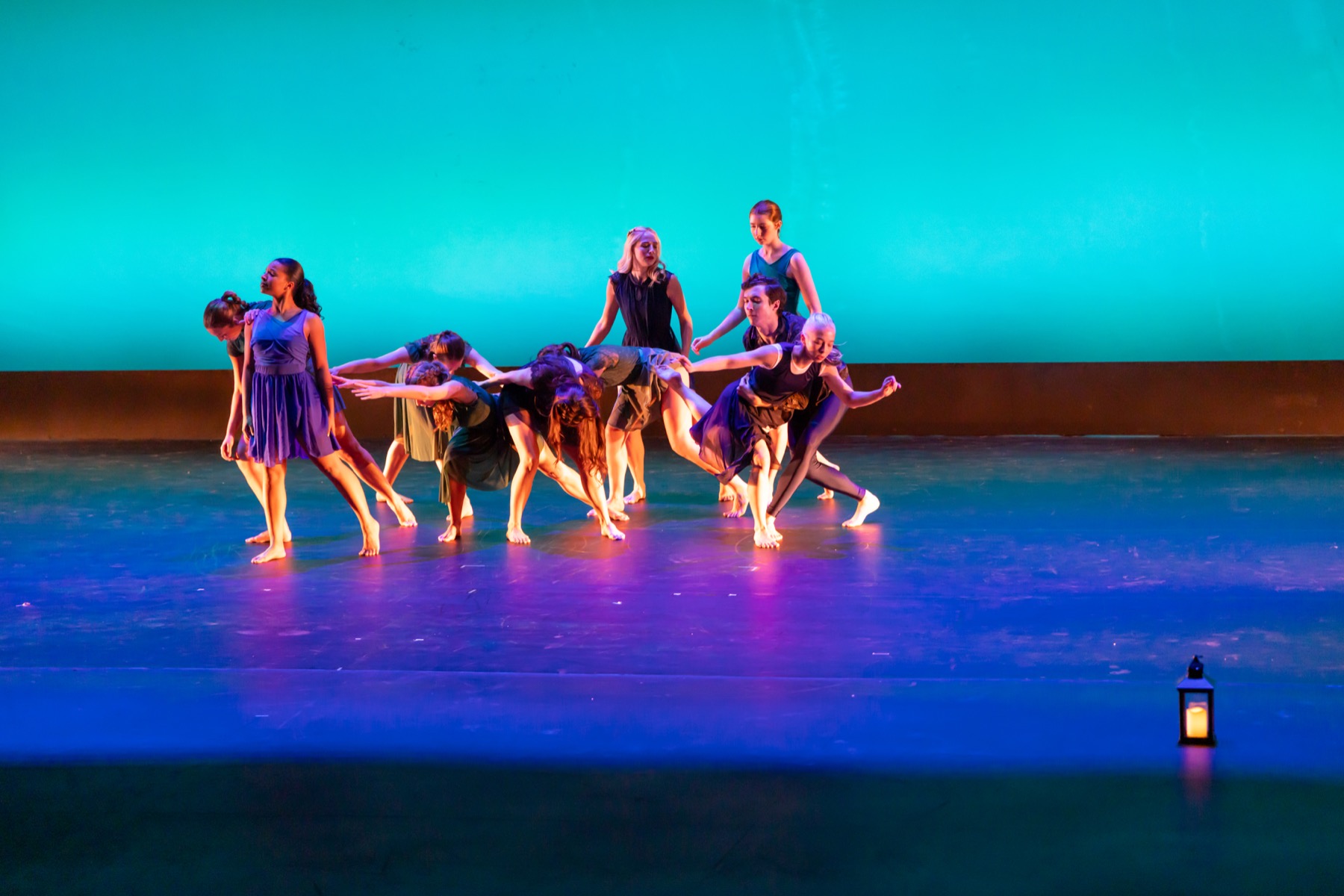 A Lamp to My Feet ensemble moving across the stage with a lantern prop
