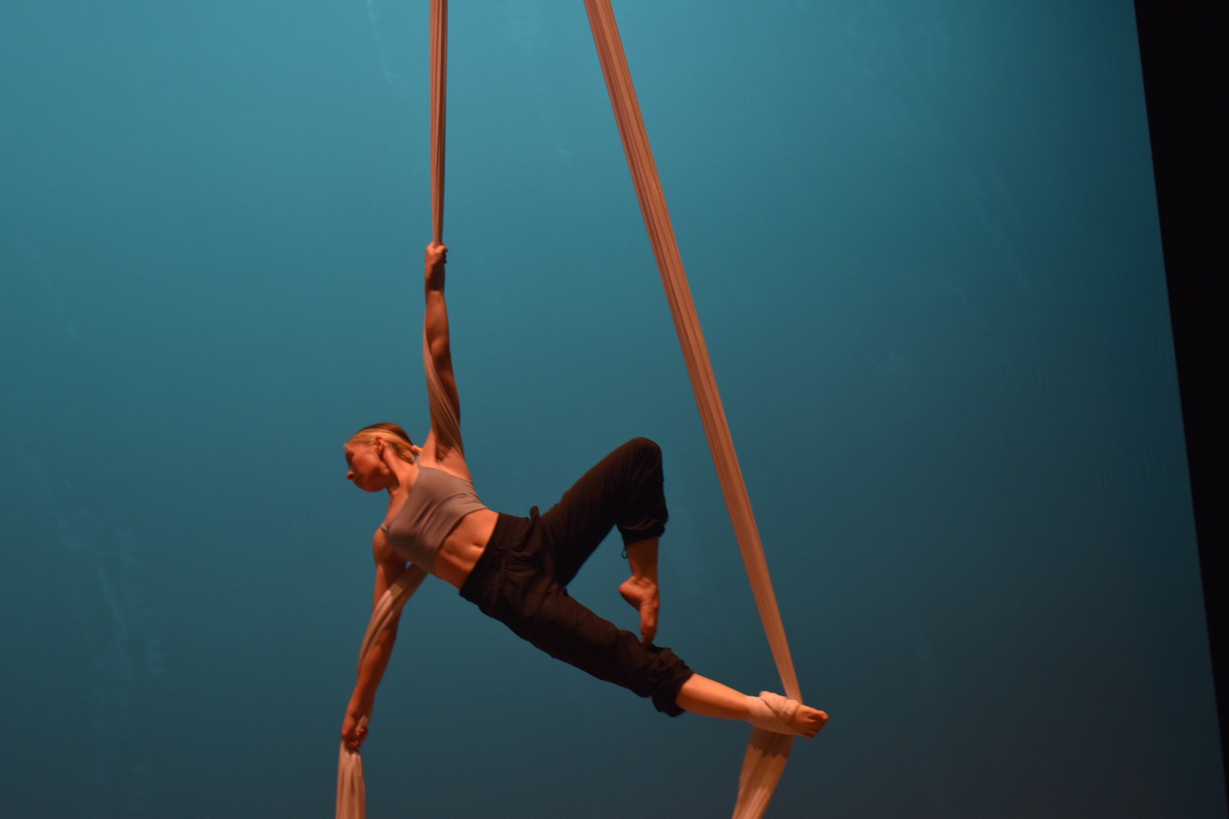Aerial fabric rehearsal with a dancer holding a diagonal suspended shape