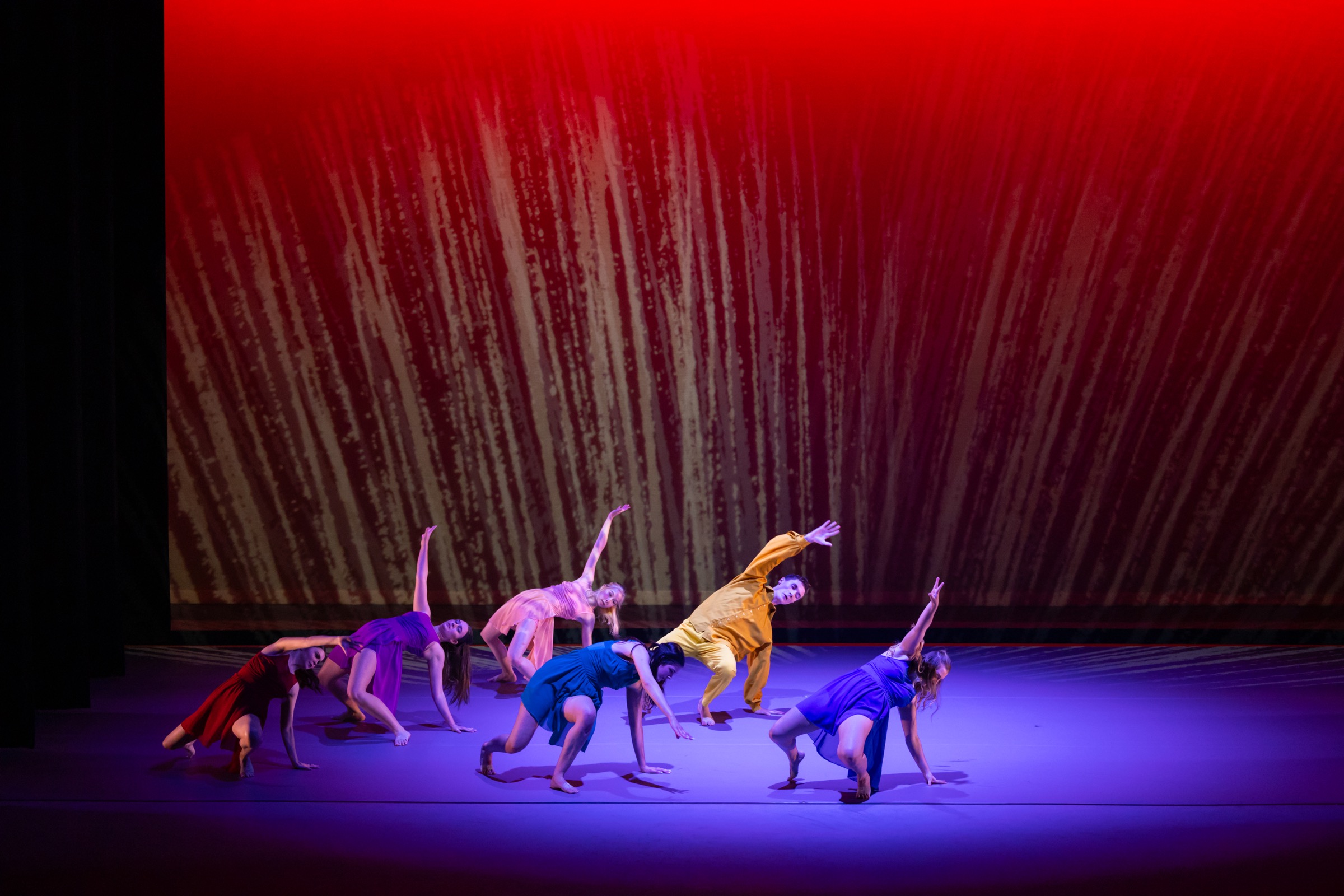 Strife ensemble performing a grounded phrase beneath red stage projections