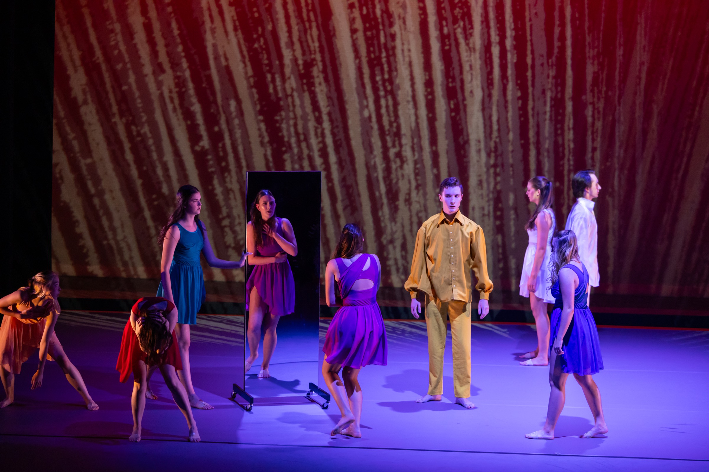 Strife dancers arranged around a mirror prop on stage