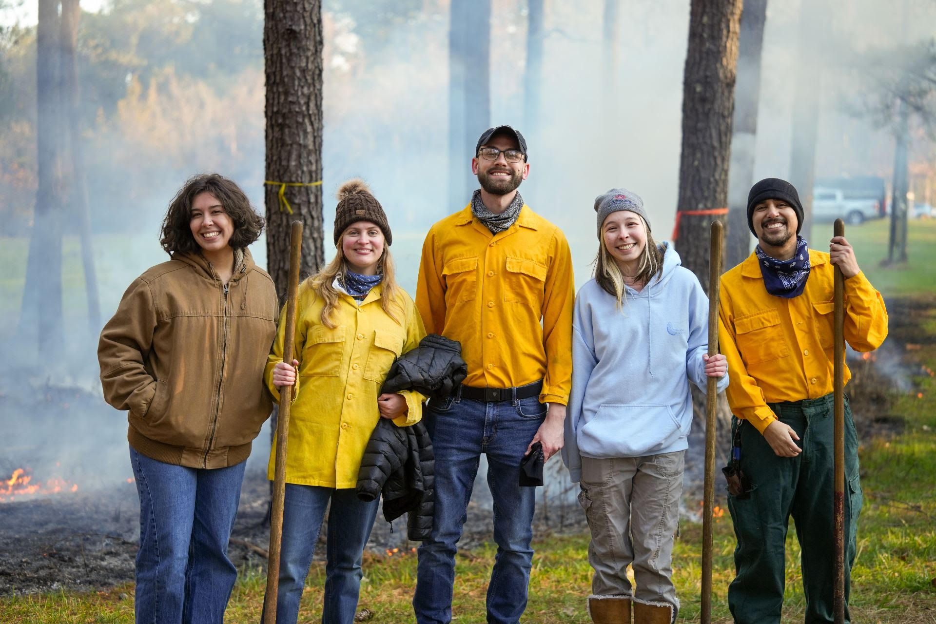 Forest and Fire Ecology Lab team standing in a smoky forest burn area