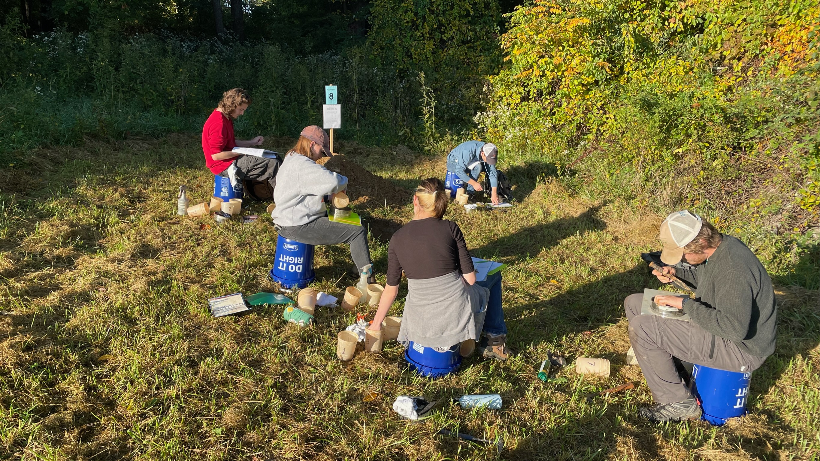 Soil judging team working through field observations in a grassy site