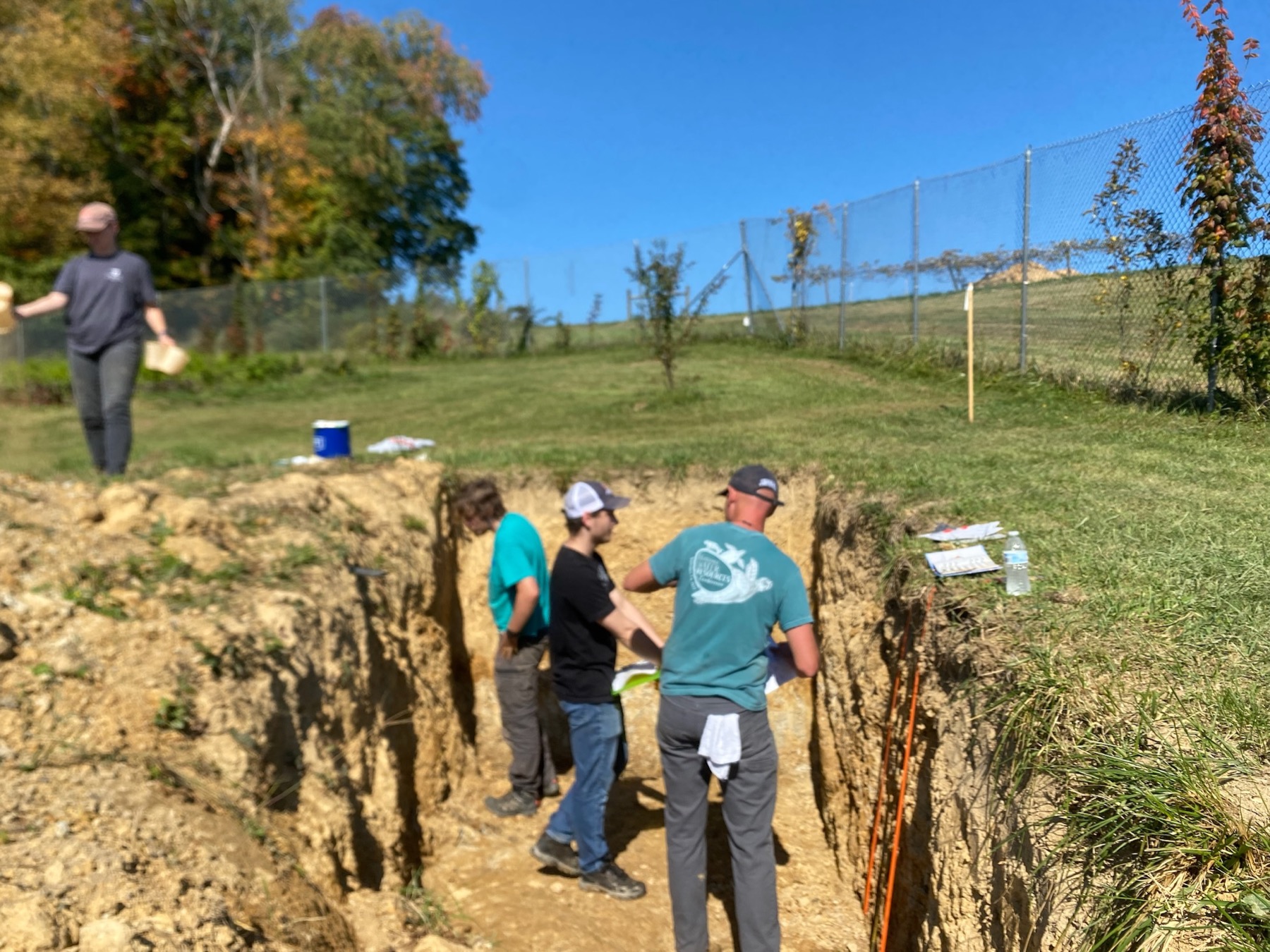 Soil judging team examining a soil pit in the field